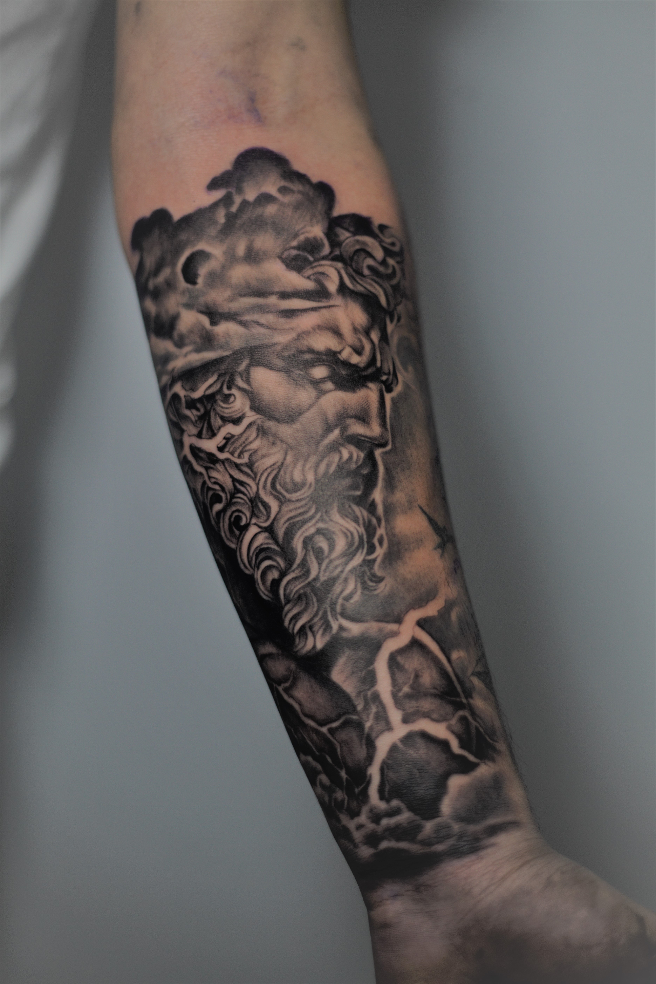Realismo blackwork — Zeus en el antebrazo